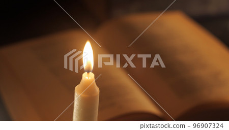 A Burning Candle and an Old Book A Burning Candle and an Old Book 96907324