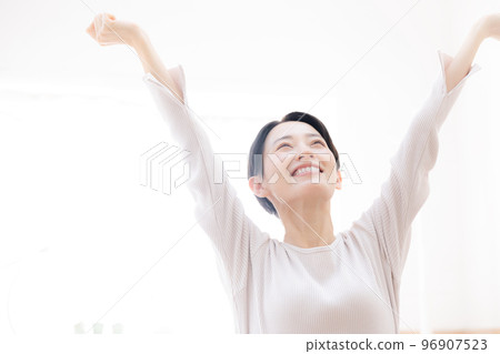 A woman stretching in the pleasant morning sun Close-up Copy space on the left 96907523