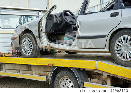 Crashed car loading into tow truck after traffic accident on road Crashed car loading into tow truck after traffic accident on road 96908160