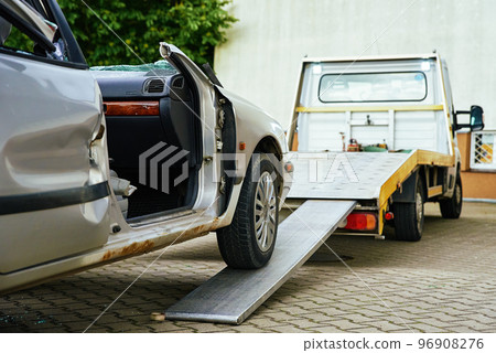 Crashed car loading into tow truck after traffic accident on road 96908276