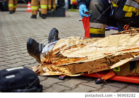 Rescuers provide first aid to the victim during car road accident 96908282