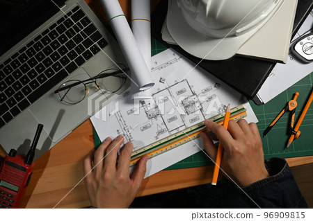 Engineer or architect man working with blueprints, planning development details at workstation 96909815