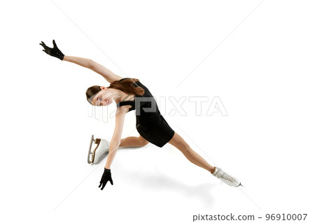 Young teen girl, junior female figure skater in black stage costume skating isolated over white background. Concept of skills, sport, beauty, winter sports 96910007