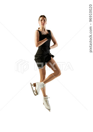Young teen girl, junior female figure skater in black stage costume skating isolated over white background. Concept of skills, sport, beauty, winter sports Young teen girl, junior female figure skater in black stage costume skating isolated over white background. Concept of skills, sport, beauty, winter sports 96910020