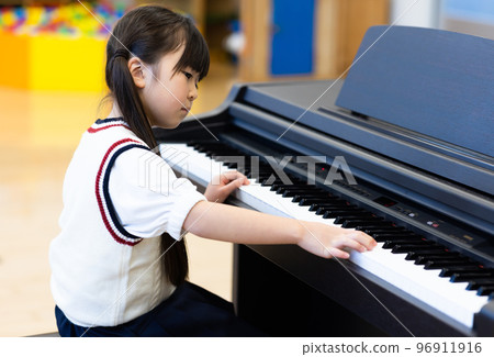 Elementary school students practicing the piano 96911916