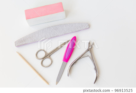 Professional manicure set on a white table. The concept of hand care, salon procedures. File, scissors, buff, bamboo stick, cuticle nippers. 96913525