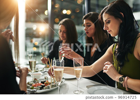 Women friends, dinner and restaurant with champagne, sushi or toast in bonding, happiness or celebration. Woman group, food and party for fine dining, friendship or conversation in night to celebrate Women friends, dinner and restaurant with champagne, sushi or toast in bonding, happiness or celebration. Woman group, food and party for fine dining, friendship or conversation in night to celebrate 96914725