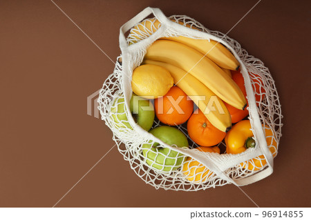 Net bag with fruits and vegetables on brown background, top view Net bag with fruits and vegetables on brown background, top view 96914855