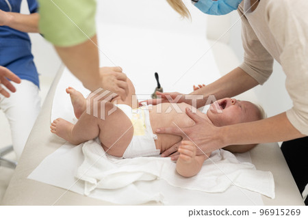 Baby beeing vaccinated by pediatrician in presence of his mother. Preventive vaccination against Diphtheria, whooping cough, tetanus, hepatitis, haemophilus influenzae, pneumococcus, poliomyelitis. 96915269