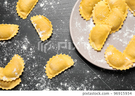 Ravioli on grey wooden table, flat lay. Italian pasta Ravioli on grey wooden table, flat lay. Italian pasta 96915934
