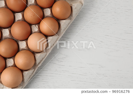 Raw chicken eggs on white wooden table, top view. Space for text 96916276