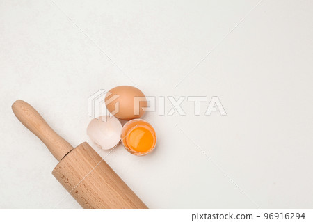Raw eggs and rolling pin on white table, top view with space for text. Baking pie Raw eggs and rolling pin on white table, top view with space for text. Baking pie 96916294
