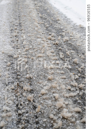 Snow day The snow begins to melt and harden on the road surface 96916585