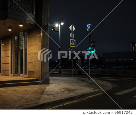 Green traffic light at the crossroads of a city street in the dark at night 96917242
