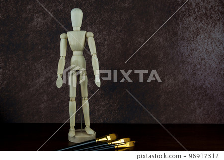 Artists Wooden Mannequin Figure with Paint Brushes on a Wooden Shelf Artists Wooden Mannequin Figure with Paint Brushes on a Wooden Shelf 96917312