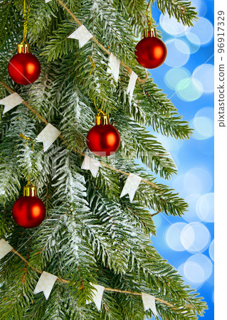 Christmas tree with red toy balls on a light blue background with bokeh lights 96917329