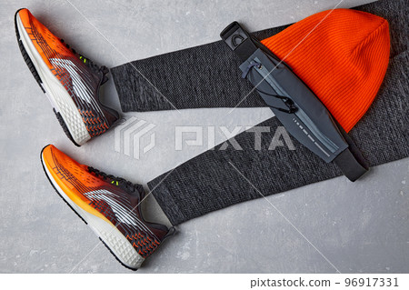 An orange knitted warm hat, warm sports leggings, a fanny pack w An orange knitted warm hat, warm sports leggings, a fanny pack w 96917331