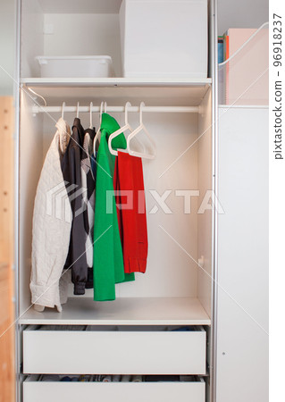 Clothes hang on a hanger in the closet. Clothes hang on a hanger in the closet. 96918237