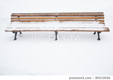 Wooden bench covered with snow. A bench in the park after a snowfall.  96919046
