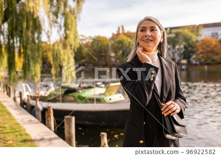 Long-haired pretty woman walking in the park Long-haired pretty woman walking in the park 96922582