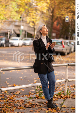 Long-haired good-looking mature woman in the street of autumn park 96922647