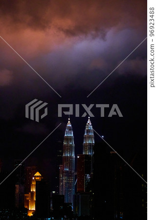The night landscape of downtown Kuala Lumpur. View of the famous petronas oil company towers. The lighting of the buildings illuminates the clouds The night landscape of downtown Kuala Lumpur. View of the famous petronas oil company towers. The lighting of the buildings illuminates the clouds 96923488