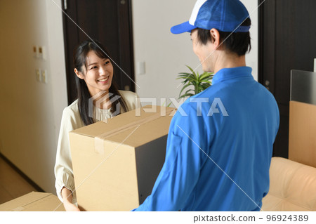 Worker and woman with cardboard indoors 96924389