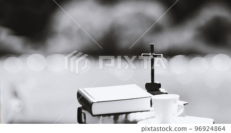 The cross of Jesus Christ, the Bible and a teacup on the shore of a serene lake in the sunlight The cross of Jesus Christ, the Bible and a teacup on the shore of a serene lake in the sunlight 96924864