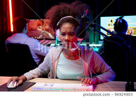 Young African American woman wearing headset play video game and live streaming online. 96924903