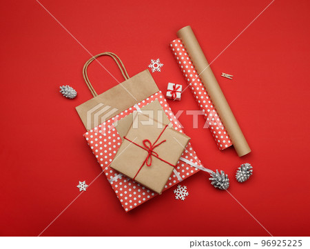 Packing Christmas gifts with red and brown paper 96925225
