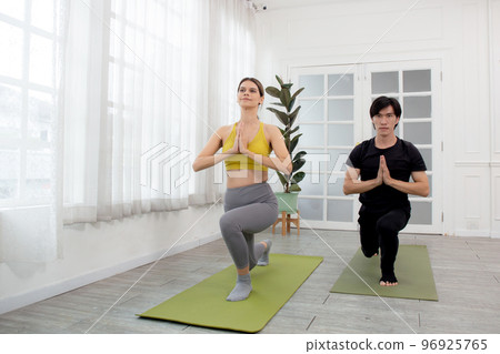 Young man and woman practicing yoga and meditating for relaxation and balance life. Young man and woman practicing yoga and meditating for relaxation and balance life. 96925765