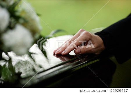 Closeup of womans hand on coffin Closeup of womans hand on coffin 96926417
