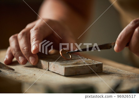 Close up of artisan jeweler holding handmade ring 96926517