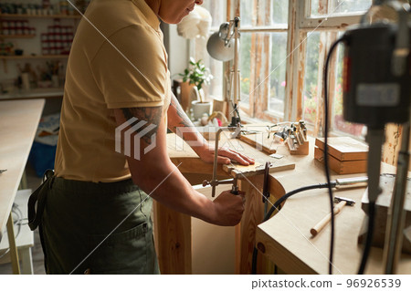 Artist cutting wood while creating handmade pieces 96926539
