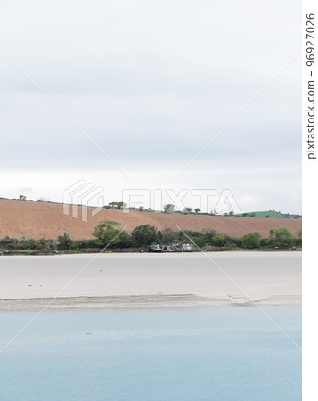 Sandy seashore. Calm water. The ship on the shore. A plowed field. Minimalistic landscape. 96927026