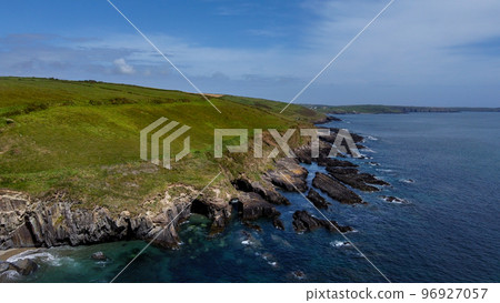 Vegetation-covered rocks on the shore of the Celtic Sea near the town of Clonakilty, County Cork, Ireland. Beautiful seascape. Nature on the Wild Atlantic Way. A natural attraction. Aerial photo. Vegetation-covered rocks on the shore of the Celtic Sea near the town of Clonakilty, County Cork, Ireland. Beautiful seascape. Nature on the Wild Atlantic Way. A natural attraction. Aerial photo. 96927057