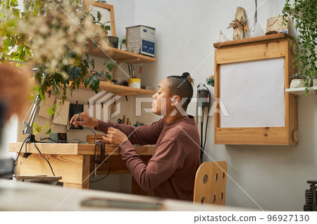 Female artist creating handmade jewelry Female artist creating handmade jewelry 96927130