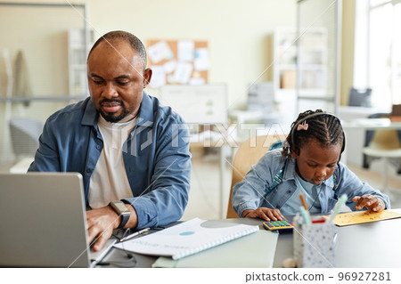 Single father working from home with child 96927281