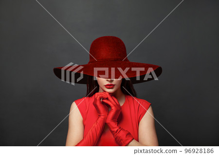 Stylish woman brunette with makeup and dark hair wearing red dress and red silk gloves  96928186