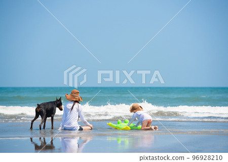 父母和孩子在海裡玩耍，還有他們的狗 96928210