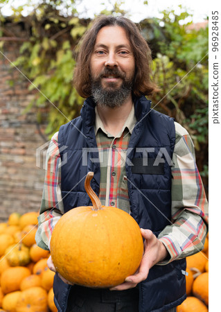 Bearded farmer with pumpkin 96928485
