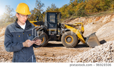 Engineer in a helmet with a digital tablet Engineer in a helmet with a digital tablet 96928506
