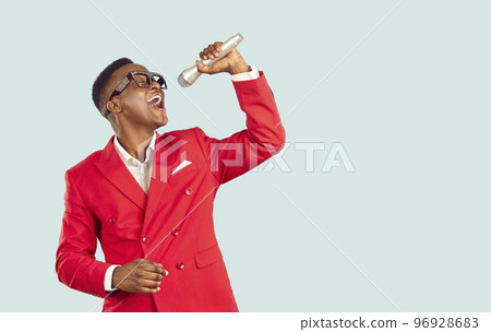 Cheerful trendy african american mc showman singing into microphone on pastel light blue background. 96928683