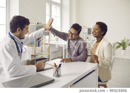 Happy male doctor give high five to excited coupe patients 96928866