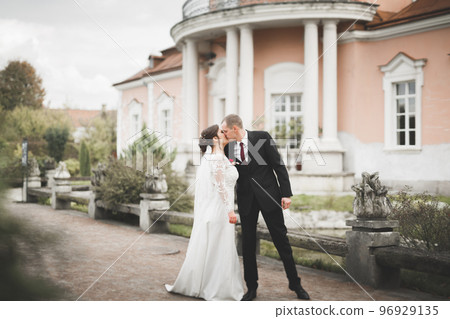 Beautiful fairytale newlywed couple hugging near old medieval castle 96929135