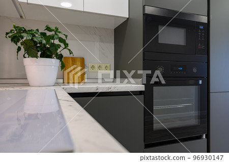 Marble worktop of modern white and dark grey kitchen Marble worktop of modern white and dark grey kitchen 96930147