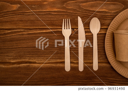 Wooden fork, spoon, knife and cardboard plate and cup on wooden background 96931498