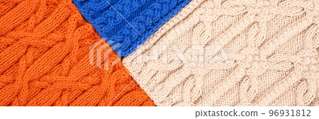 Knitted blue orange and beige background. Large knitted fabric with a pattern. Close-up of a knitted blanket. Banner Knitted blue orange and beige background. Large knitted fabric with a pattern. Close-up of a knitted blanket. Banner 96931812