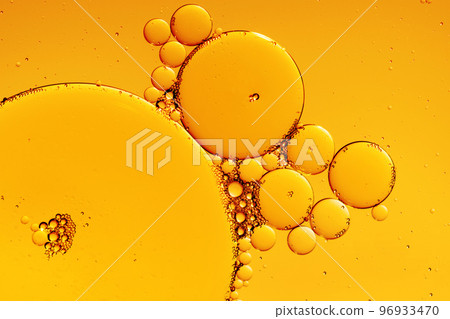 Golden yellow abstract oil bubbles or face serum background. Oil and water bubbles macro photography. 96933470