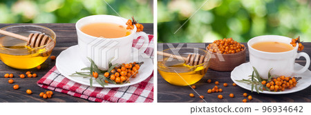 Tea of sea-buckthorn berries with honey on wooden table blurred garden background 96934642